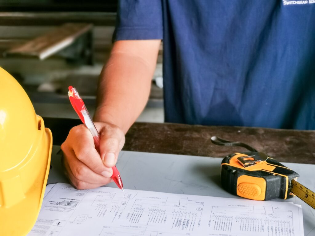 Supervisor working at factory with drawing plan.